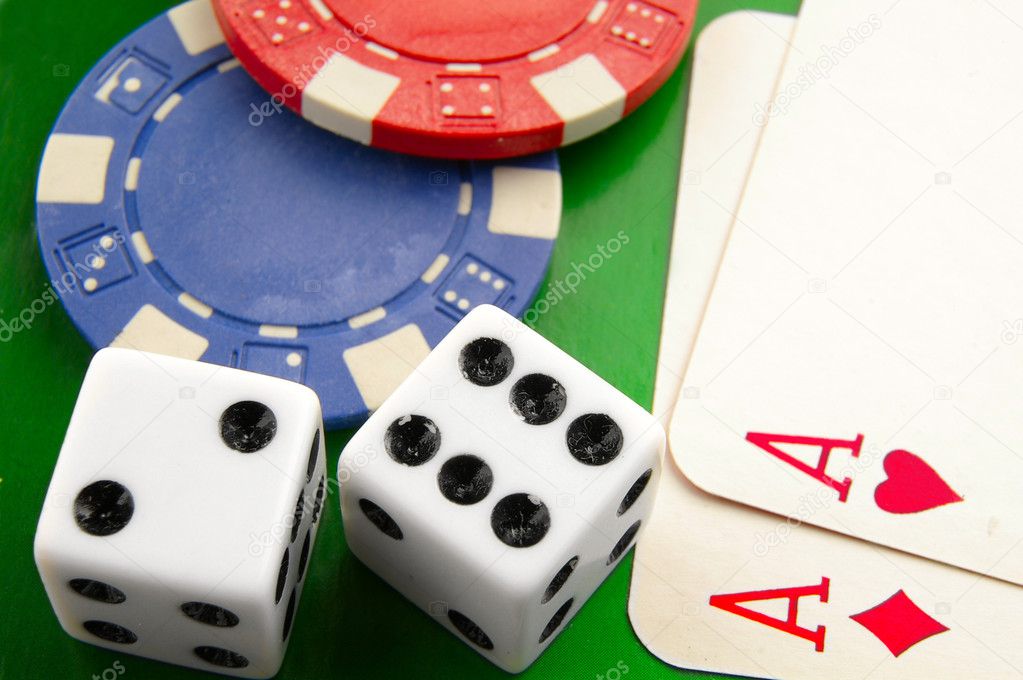 Stacked poker chips and dice on white