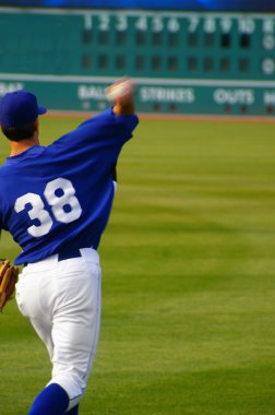 Baseball player throwing the ball, with scoreboard in the background clipart