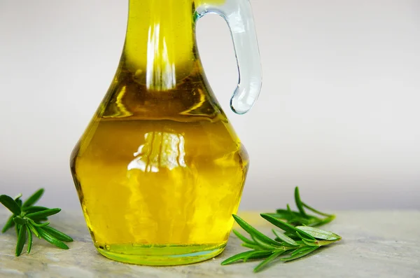 Olio d'oliva in un contenitore di vetro, con rosmarino fresco — Foto Stock