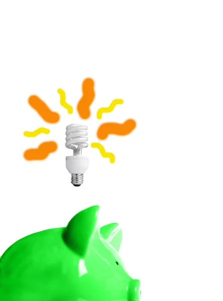 Salvadanaio verde con lampadina a basso consumo energetico sopra — Foto Stock