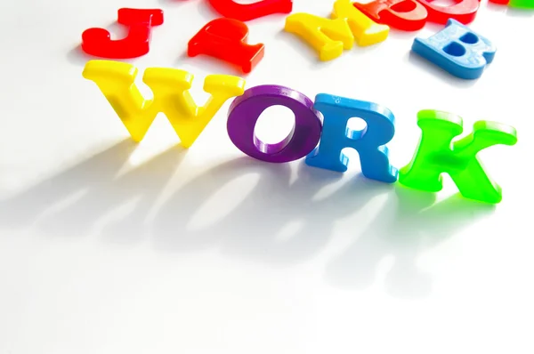 Bunte Plastikbuchstaben für Kinder schreiben "Arbeit"" — Stockfoto