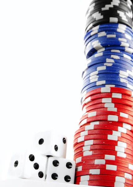 Stacked poker chips cash and dice on white — Stock Photo, Image