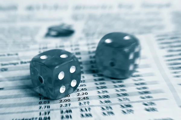 Two dice on a newspaper stock market page
