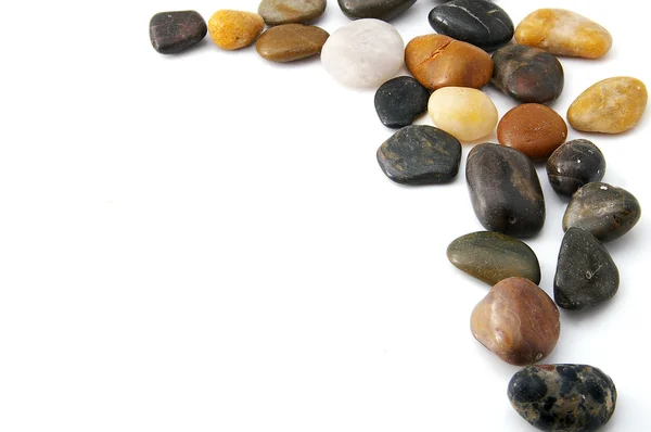 Pedras de rio lisas variadas em uma borda — Fotografia de Stock
