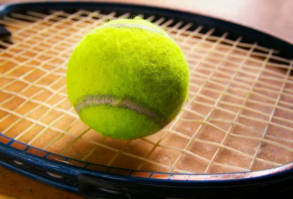 Primer plano de una pelota de tenis en cuerdas de raqueta — Foto de Stock