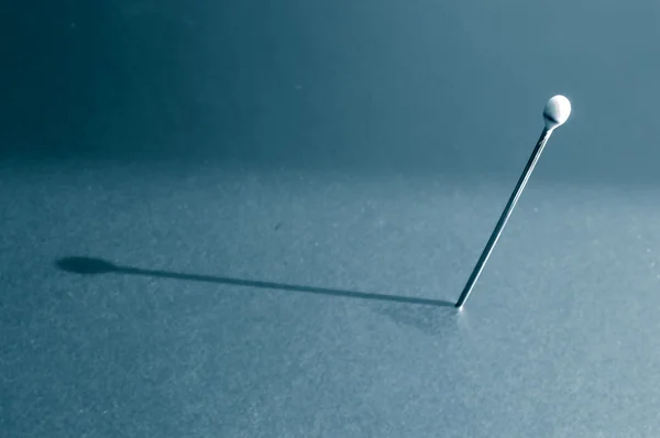 Single stuck pin and its shadow — Stock Photo, Image