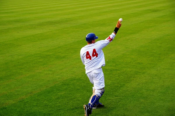 Baseballspieler wirft den Ball, mit Anzeigetafel im Hintergrund — Stockfoto