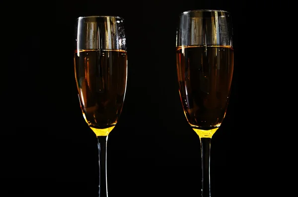 Copas de champán juntos sobre fondo negro — Foto de Stock