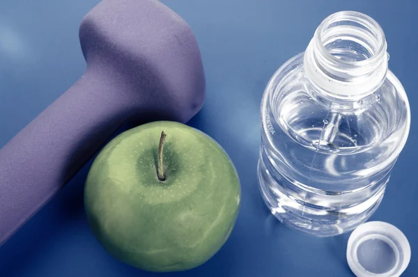 Bootle of water, weight and green apple — Stock Photo, Image