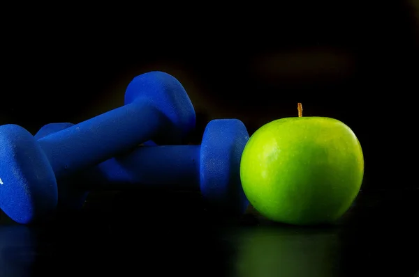 Apfel und zwei Handgewichte — Stockfoto