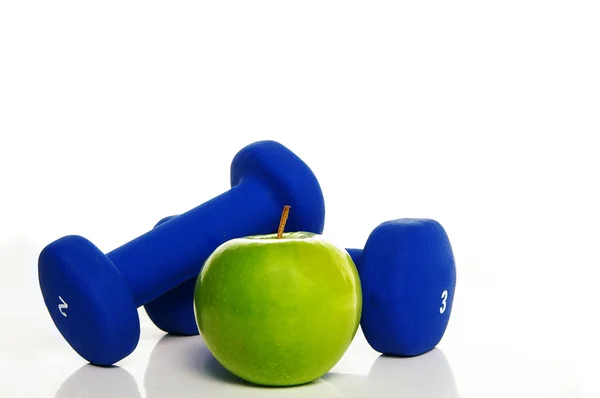 Pesos e uma maçã verde — Fotografia de Stock