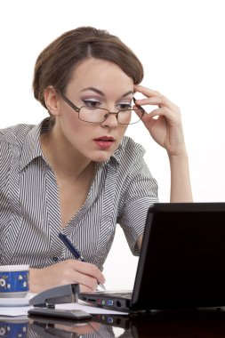 bir dizüstü bilgisayar üzerinde çalışan genç iş kadını