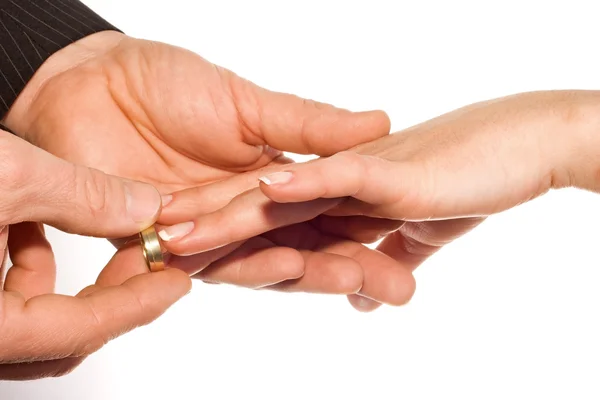 Hombre poniendo anillo de bodas en el dedo de la novia Imagen de archivo