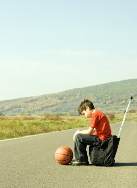 Young boy hitching on road clipart