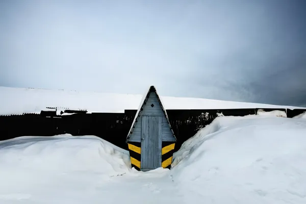 WC omringd door sneeuw in de winter in de buurt van hek — Stockfoto