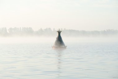 River buoy on surface of river in a fog clipart