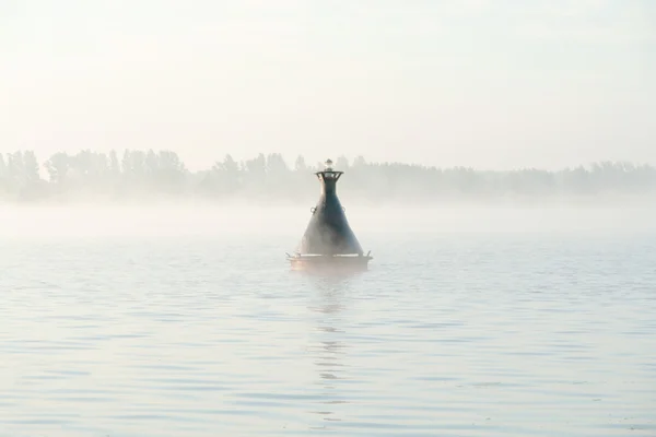 stock image River buoy on surface of river in a fog