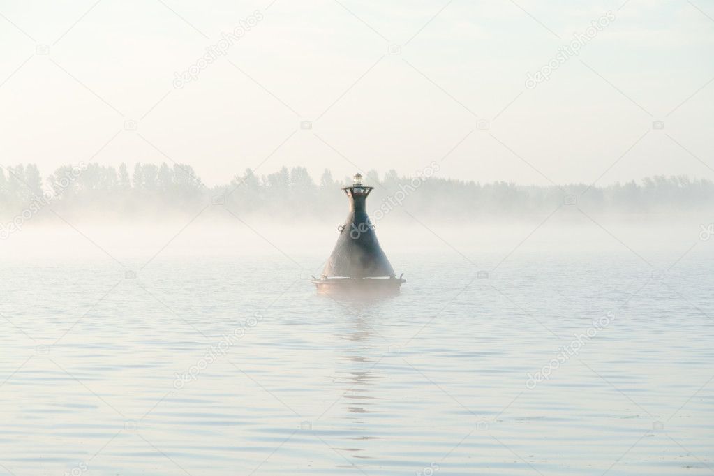 River buoy on surface of river in a fog