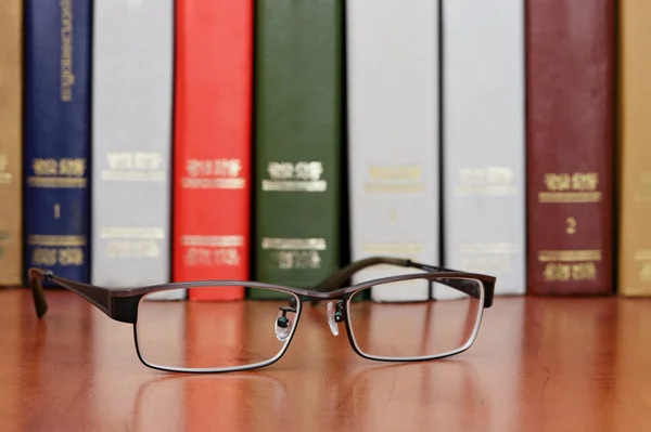 Brille im Bücherregal — Stockfoto