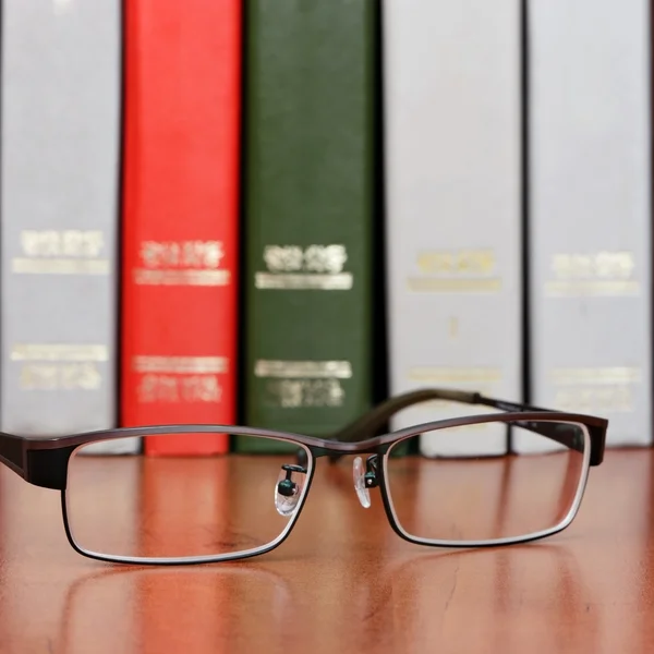 Brille im Bücherregal — Stockfoto