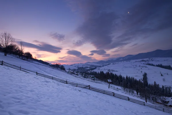 Nascer do sol em montanhas de inverno com lua — Fotografia de Stock