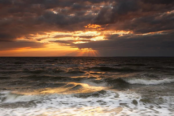 Zonsondergang op de stormachtige zee — Stockfoto