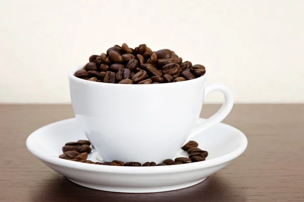 White cup of coffee beans — Stock Photo, Image