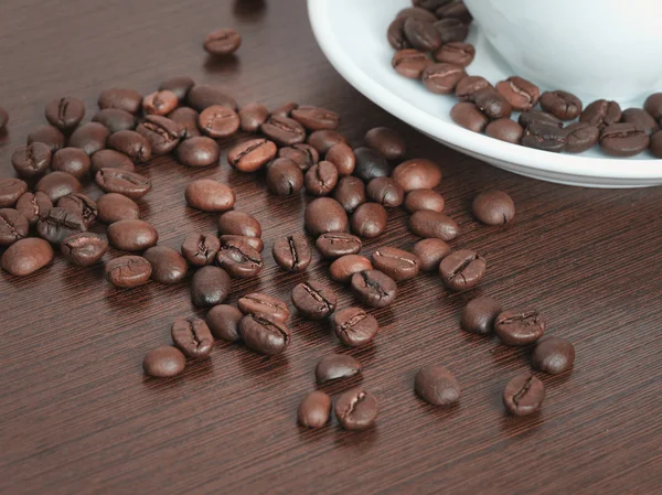 Xícara de grãos de café em uma mesa — Fotografia de Stock
