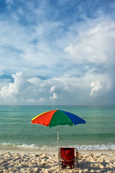 Spiaggia soleggiata e ombrellone colorato — Foto Stock