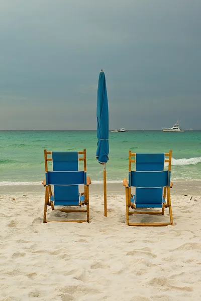 Liegestühle am Strand über bewölktem Himmel — Stockfoto