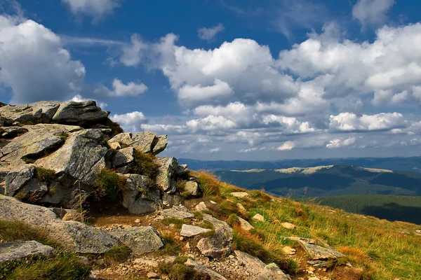 Corrediça de montanha rochosa contra o céu azul nublado — Fotografia de Stock