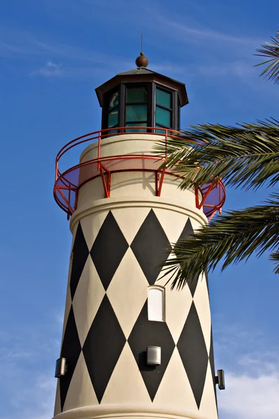 Old lighthouse over blue sky and palm trees — Stock Photo, Image
