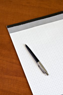 Close-up of notebook and a black pen clipart