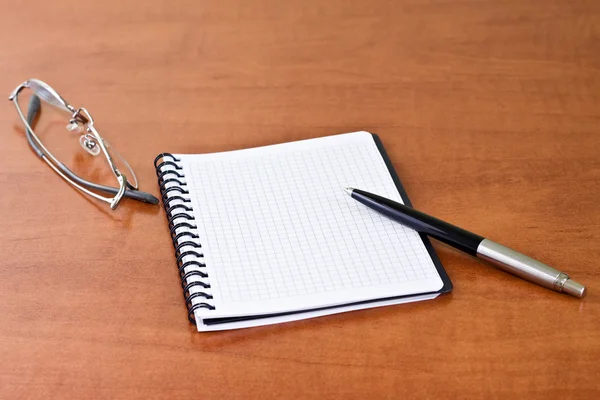 Zwarte pen met notebook en glazen — Stockfoto