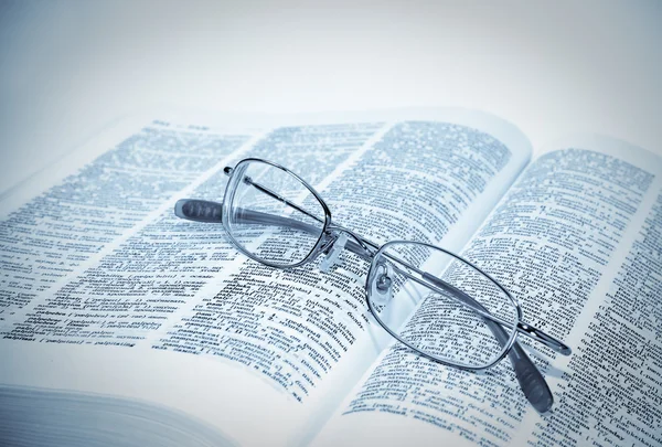 Nahaufnahme von aufgeschlagenem Buch und Brille — Stockfoto