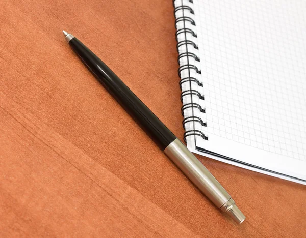 Ручка с белой спиралью в квадрате ноутбука — стоковое фото
