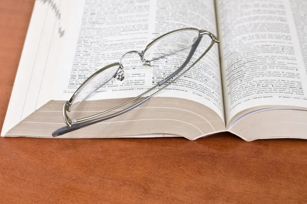 Книга с очками — стоковое фото