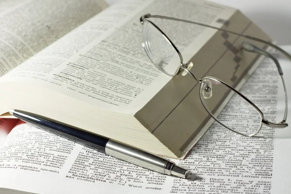 Livros com óculos de leitura e caneta — Fotografia de Stock