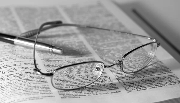 Libro abierto, gafas y bolígrafo —  Fotos de Stock