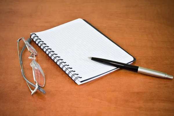 Ноутбук, очки и ручка — стоковое фото