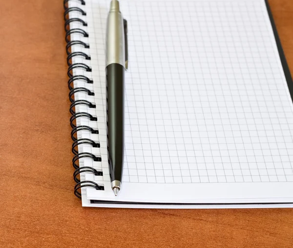 Рабочий стол с ручкой и ноутбуком — стоковое фото