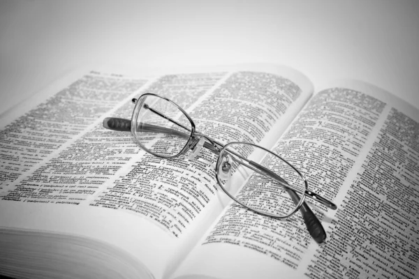 Närbild av öppnade boken och glasögon — Stockfoto