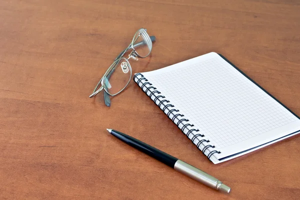 Arrangör, glasögon och pennan på bordet — Stockfoto