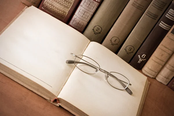 Kniha a brýle v knihovně — Stock fotografie