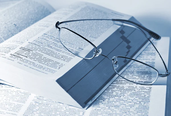 Närbild av öppnade böcker och glasögon — Stockfoto