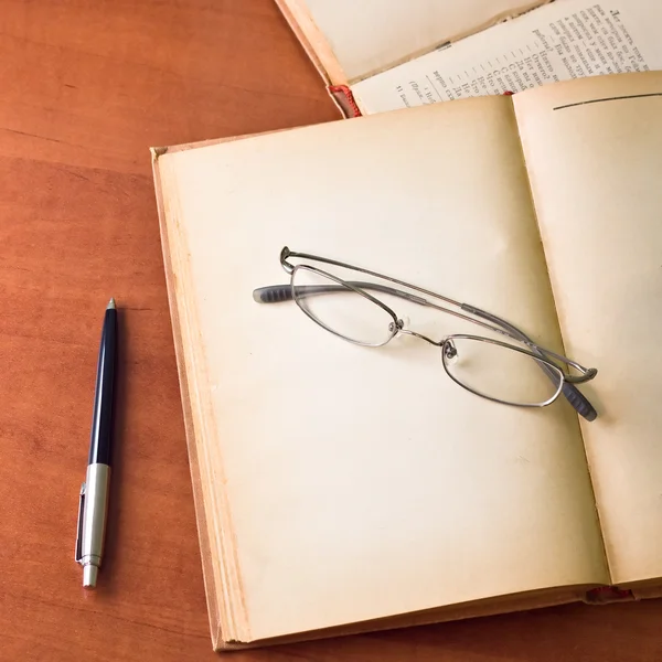 Livros antigos com óculos de leitura e caneta — Fotografia de Stock