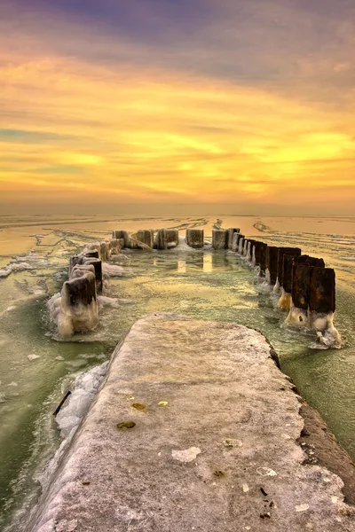 Molo morze pokryte lodem na zachodzie słońca — Zdjęcie stockowe
