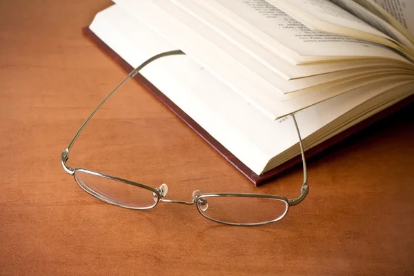 Closeup of opened book and glasses — Stock Photo, Image
