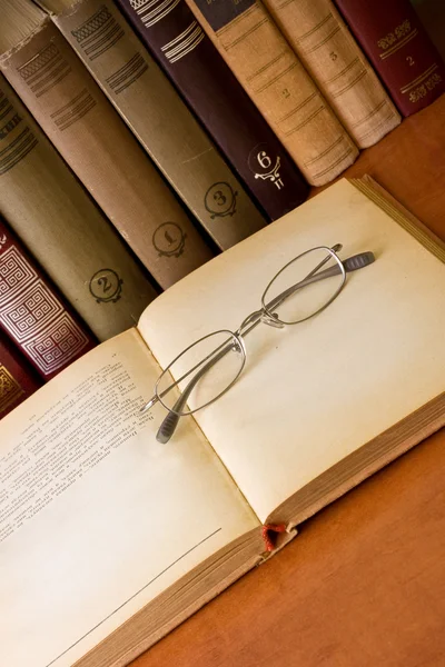 Eski bir kitap üzerine eski gözlük camı — Stok fotoğraf