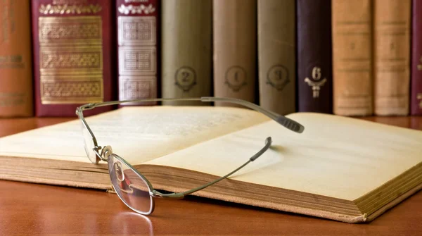 Gözlük önünde eski bir kitap — Stok fotoğraf